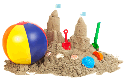 Sand castle with various summer toys in and around it.
